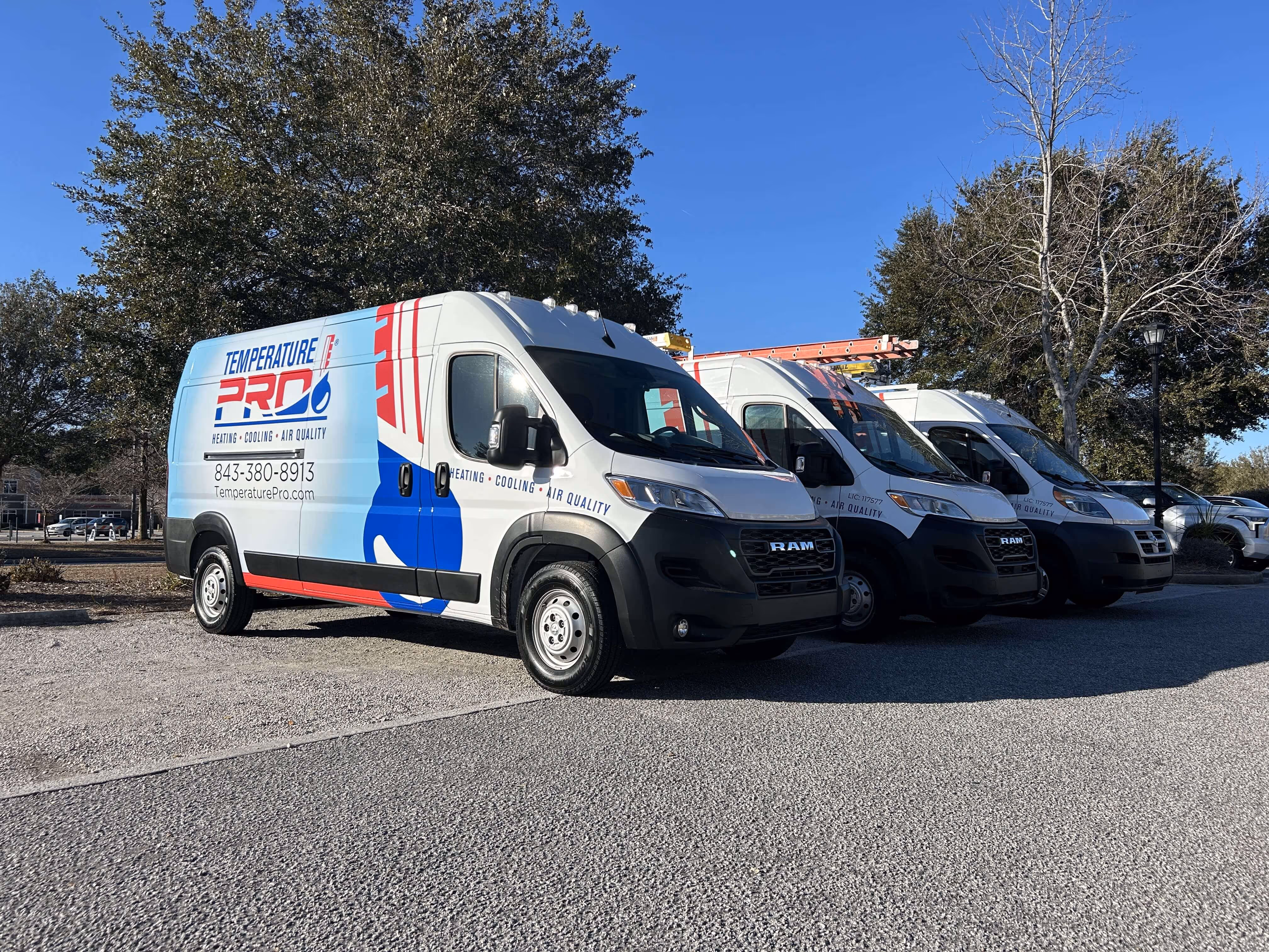 A group of company vans parked in a parking lot.