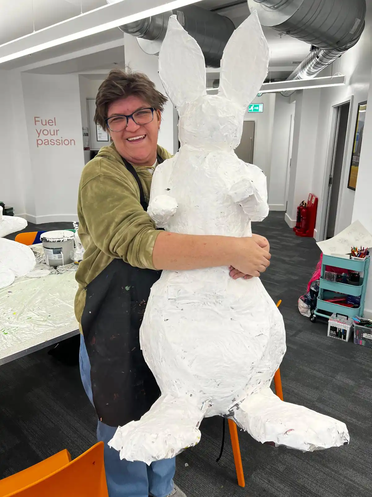 ArtWorks artist, Sian, holding a sculpture of a bunny they created.
