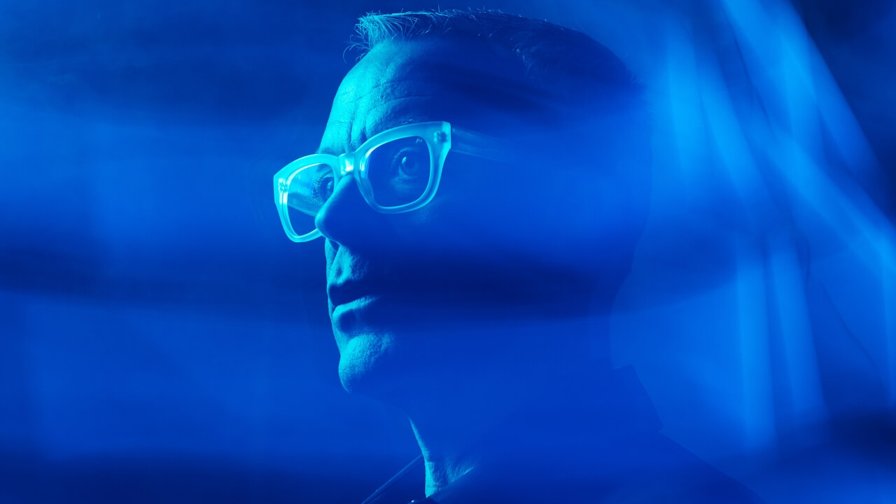 Man in translucent glasses lit by blue light