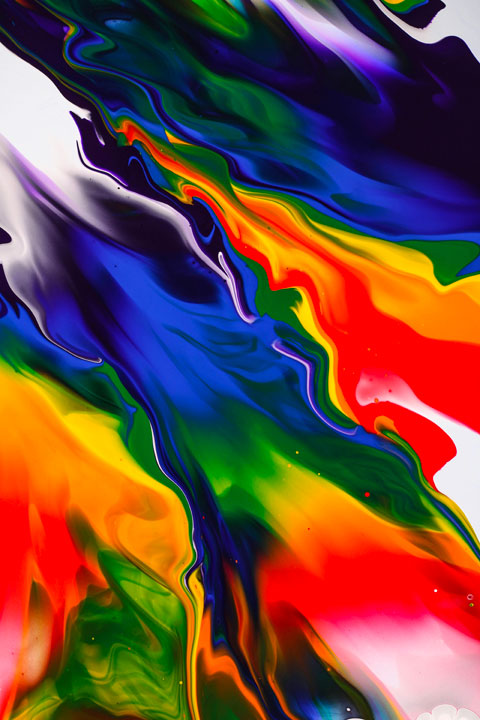 Swirls of blue, red, yellow and green fluid paint