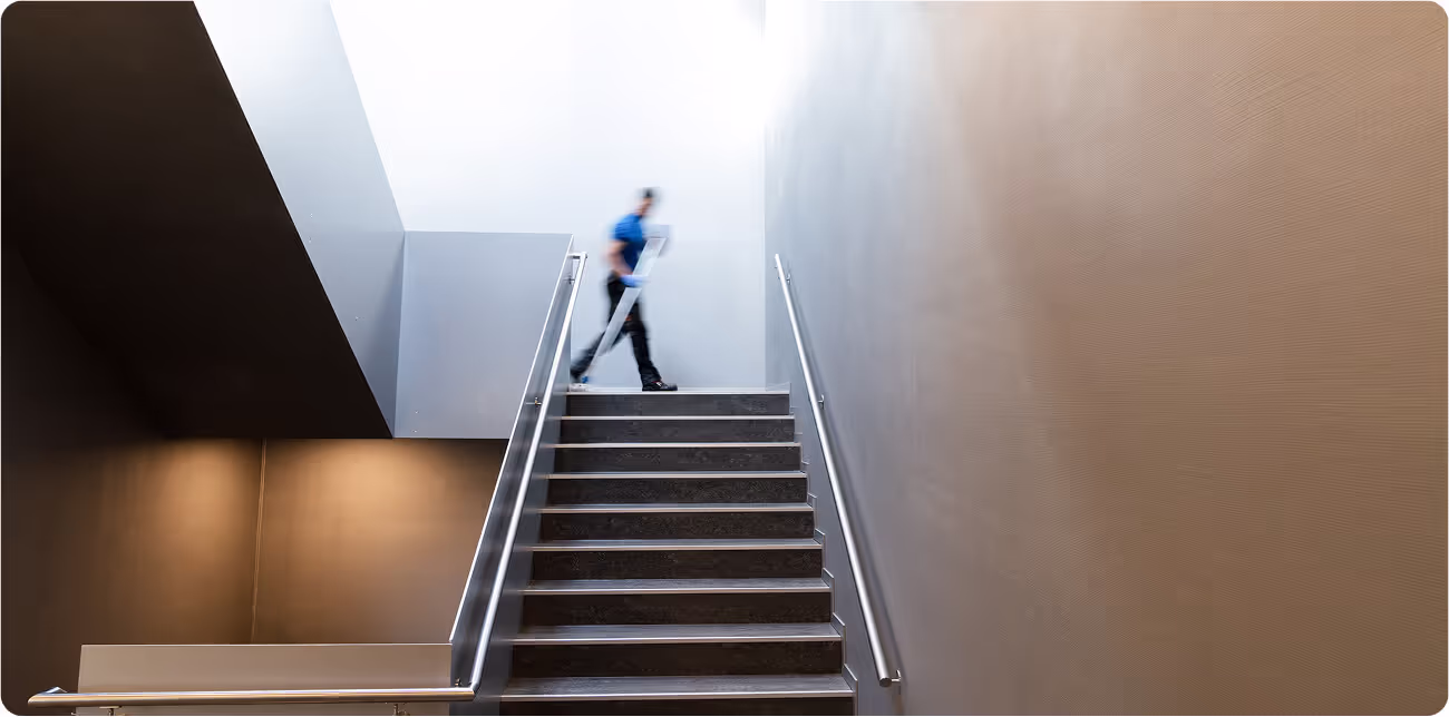 Eine verschwommene Person, die eine moderne Treppe reinigt und unsere Reinigungsdienstleistungen darstellt.