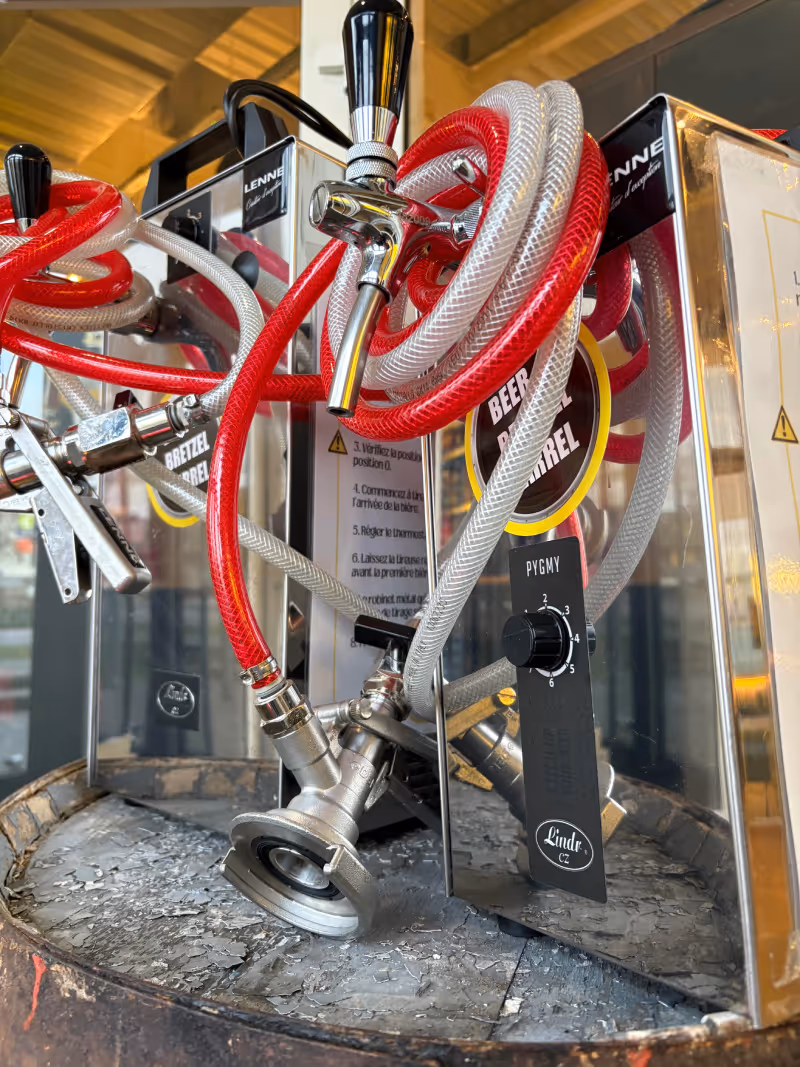Tireuse à bière chromée sur un tonneau en bois.