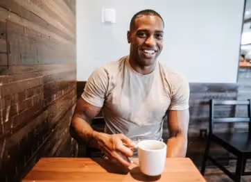 Smiling man sits at the cafe