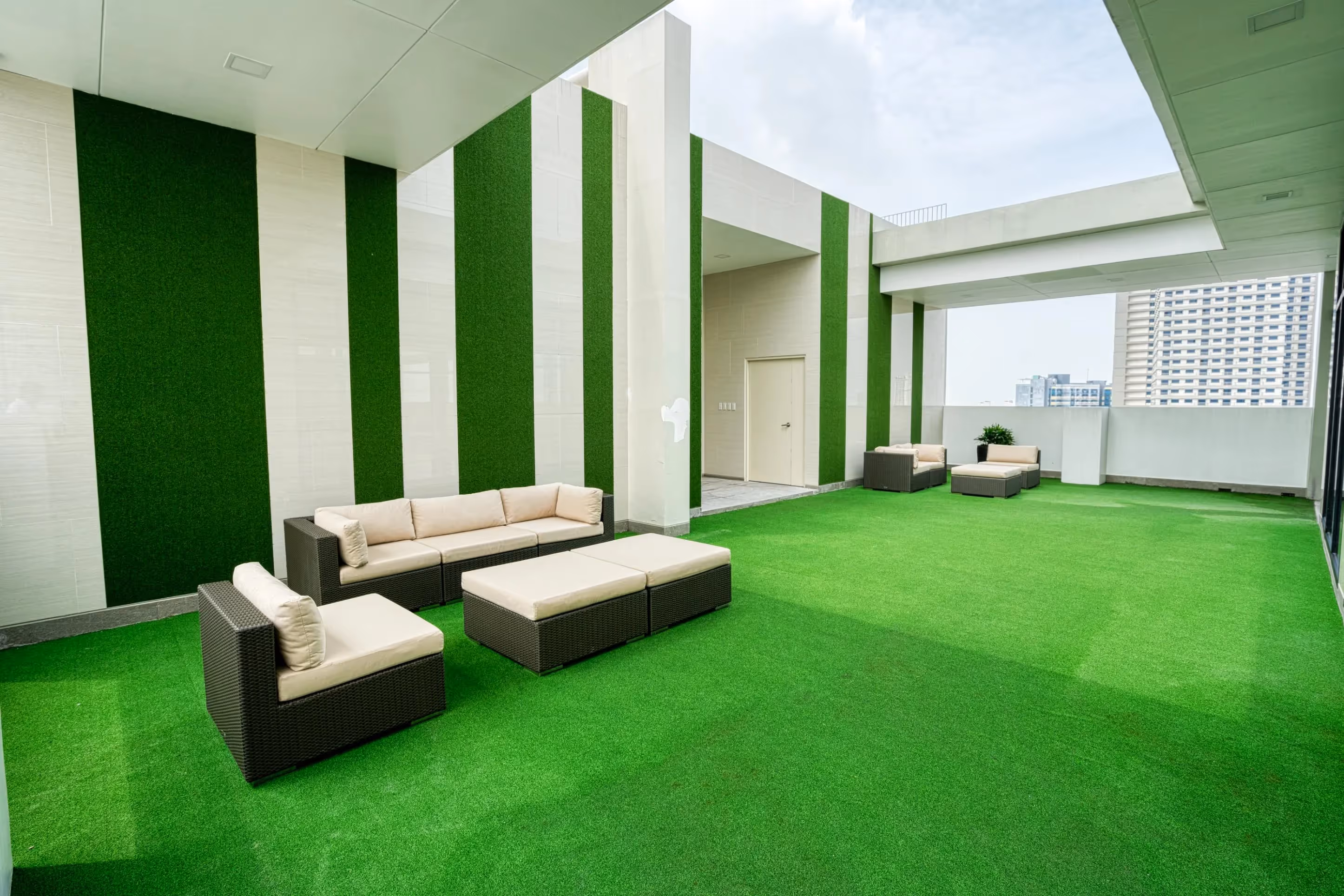 Rooftop deck with artificial grass and modern outdoor seating at 3Torre Lorenzo.