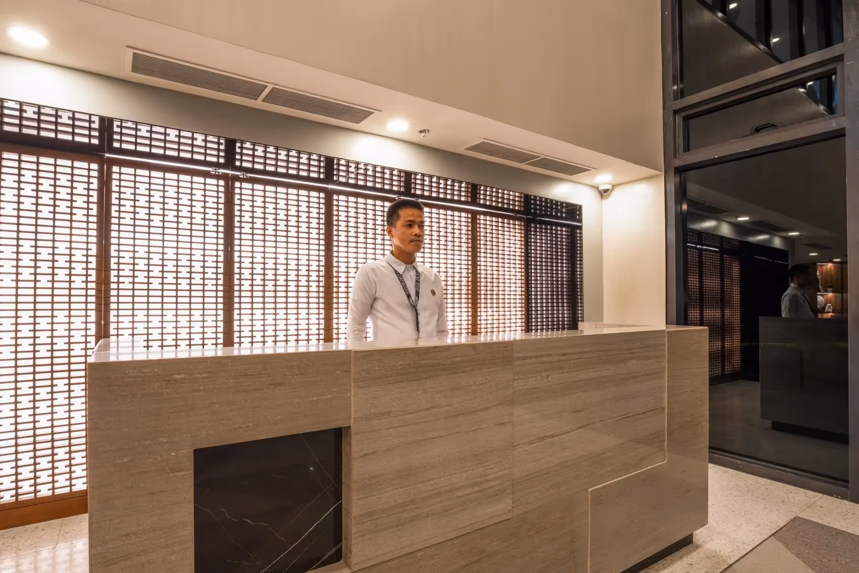 Concierge desk with modern design and textured wall backdrop at Torre Lorenzo Loyola East Tower.