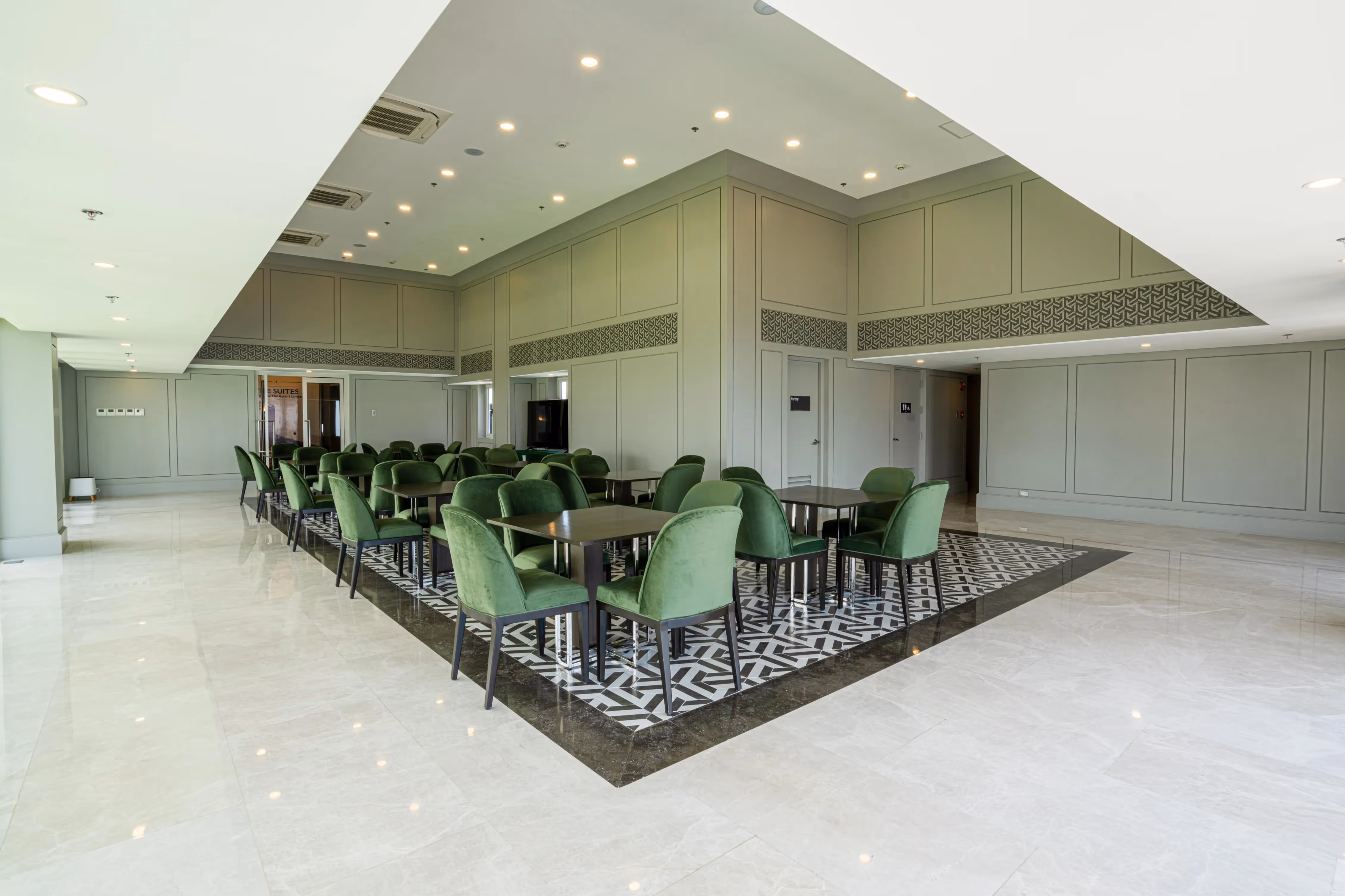 Spacious dining area with green chairs and patterned tile flooring.