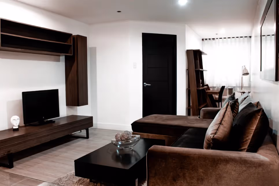 Contemporary living area with brown couches and entertainment center at 1Torre Lorenzo.