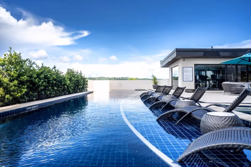 Outdoor pool with sun loungers and landscaped surroundings at Dusit Thani Residence Davao.