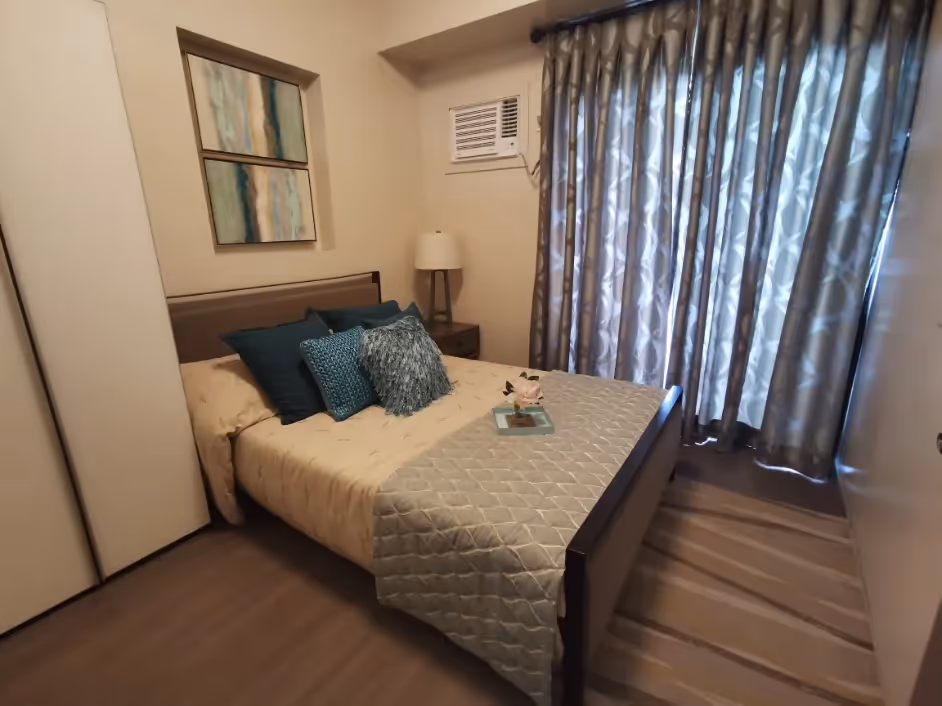 Stylish Adria unit bedroom with cozy double bed and floor-to-ceiling curtains at Adria.