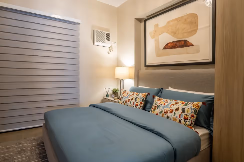Cozy one-bedroom unit with a soft-toned interior and comfortable bed at Merano, Tierra Lorenzo Lipa.