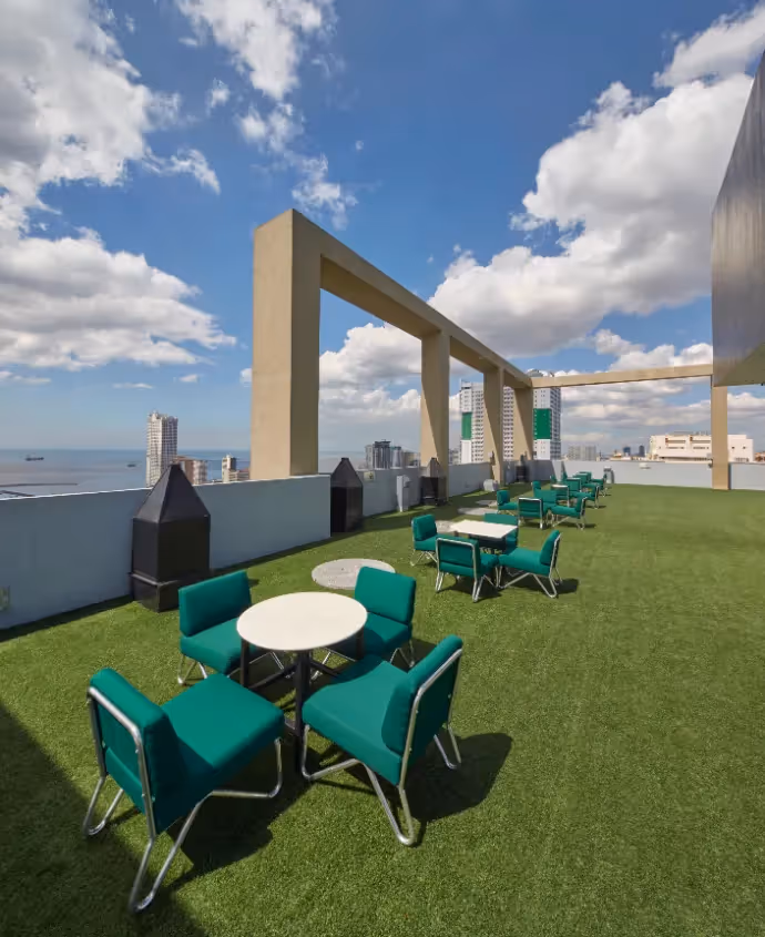 Rooftop deck with green open space and seating offering city views at 2Torre Lorenzo.