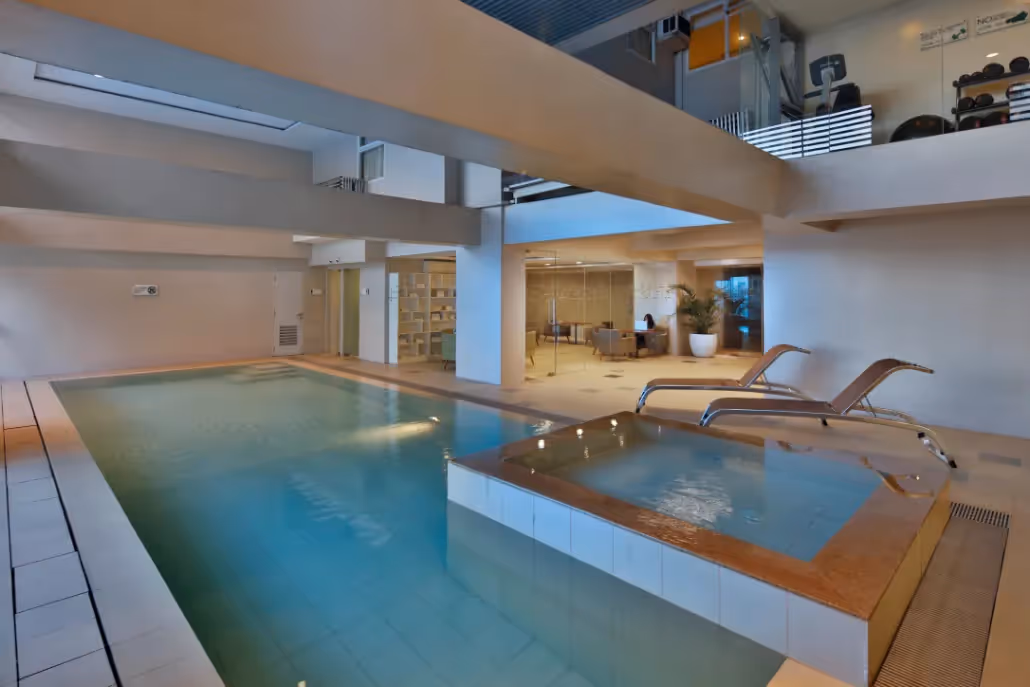 Indoor swimming pool with modern design and lounge area at 2Torre Lorenzo.