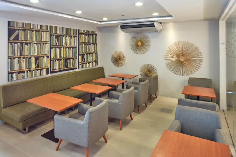 Cozy study lounge with bookshelves and comfortable seating at 2Torre Lorenzo.