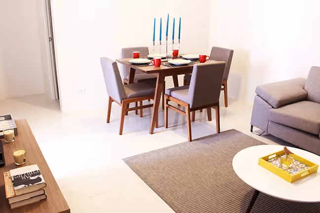 Dining area with a modern four-seater table and bright interior at 2Torre Lorenzo.