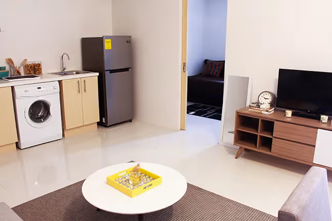 Open-plan living area with a compact kitchen and washing machine at 2Torre Lorenzo.