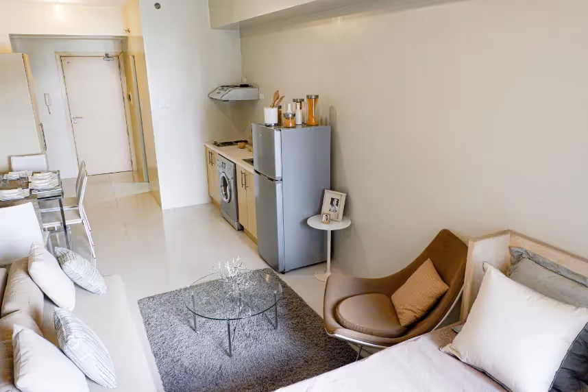 Small living area with neutral furnishings and wall-mounted storage at 2Torre Lorenzo.