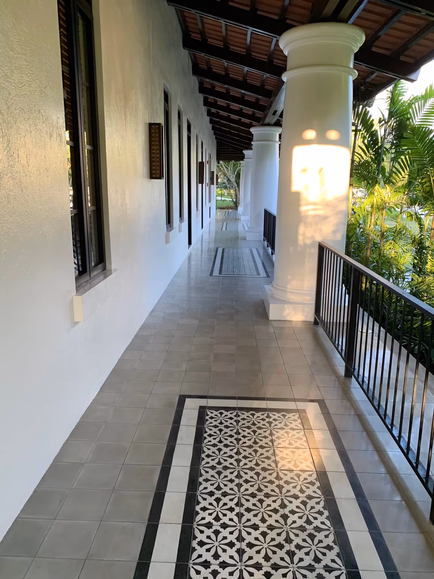 Elegant hallway with patterned floor and hanging lights at Dusit Thani Lubi Plantation Resort.