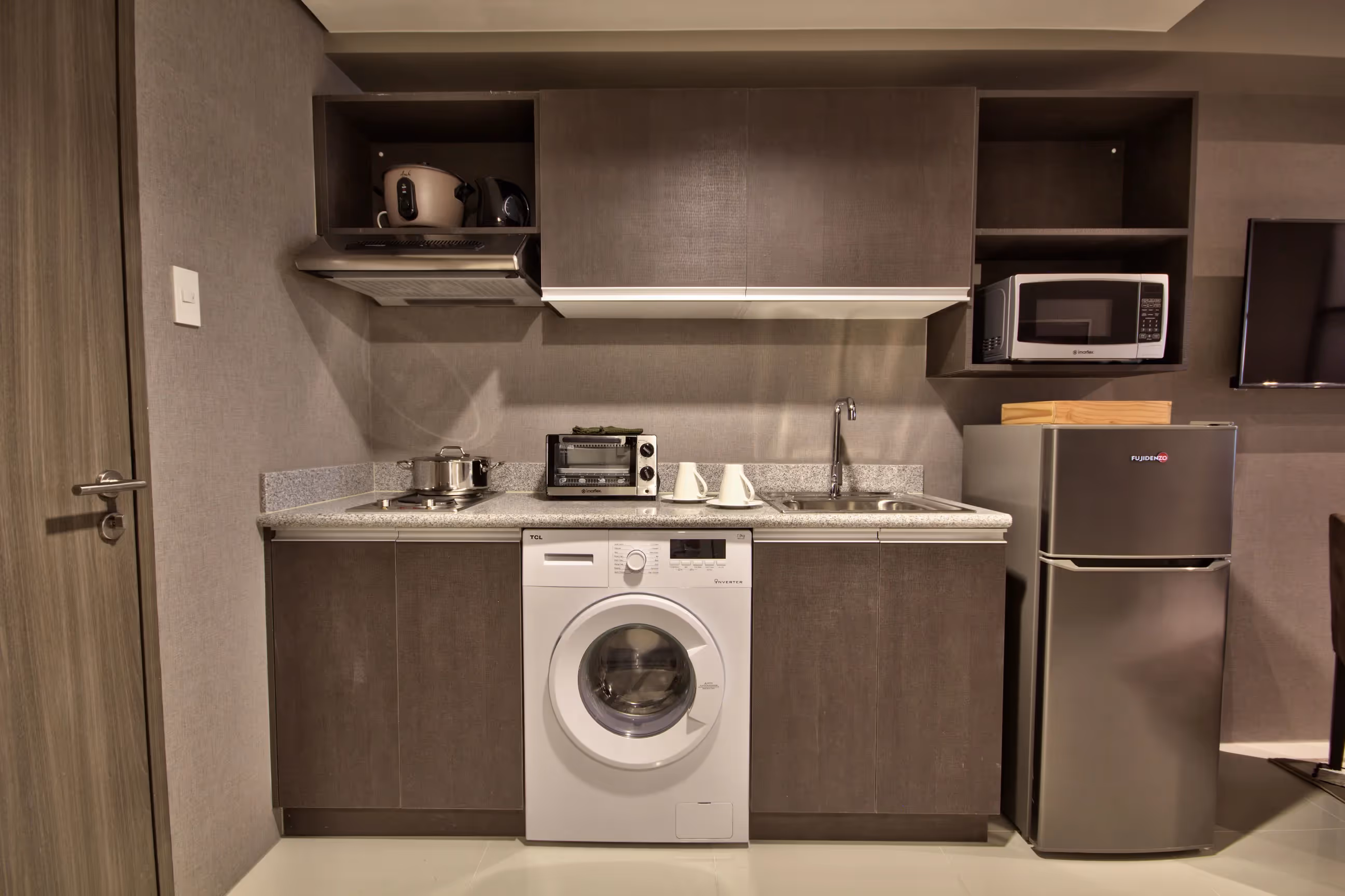 Compact kitchen with built-in appliances and washing machine.