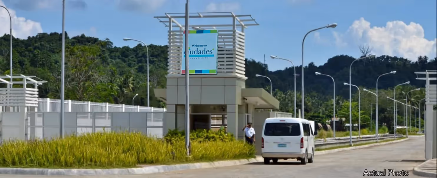 Entrance of Ciudades development with prominent logo and landscaping.