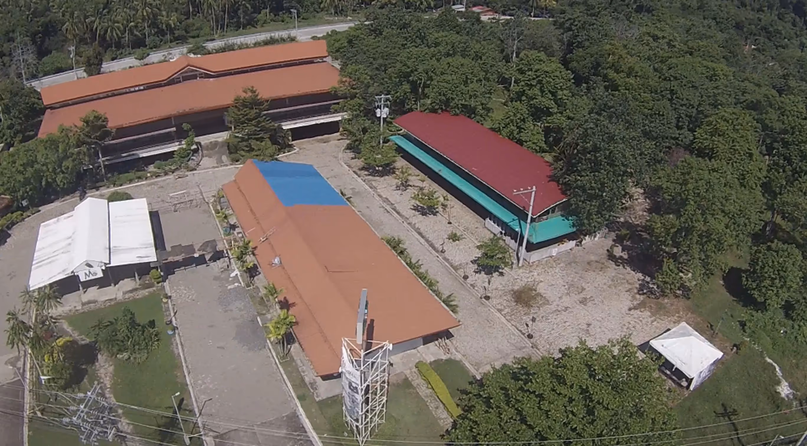 Aerial view of Ciudades Business Park showing open land, developing infrastructure, and surrounding greenery.