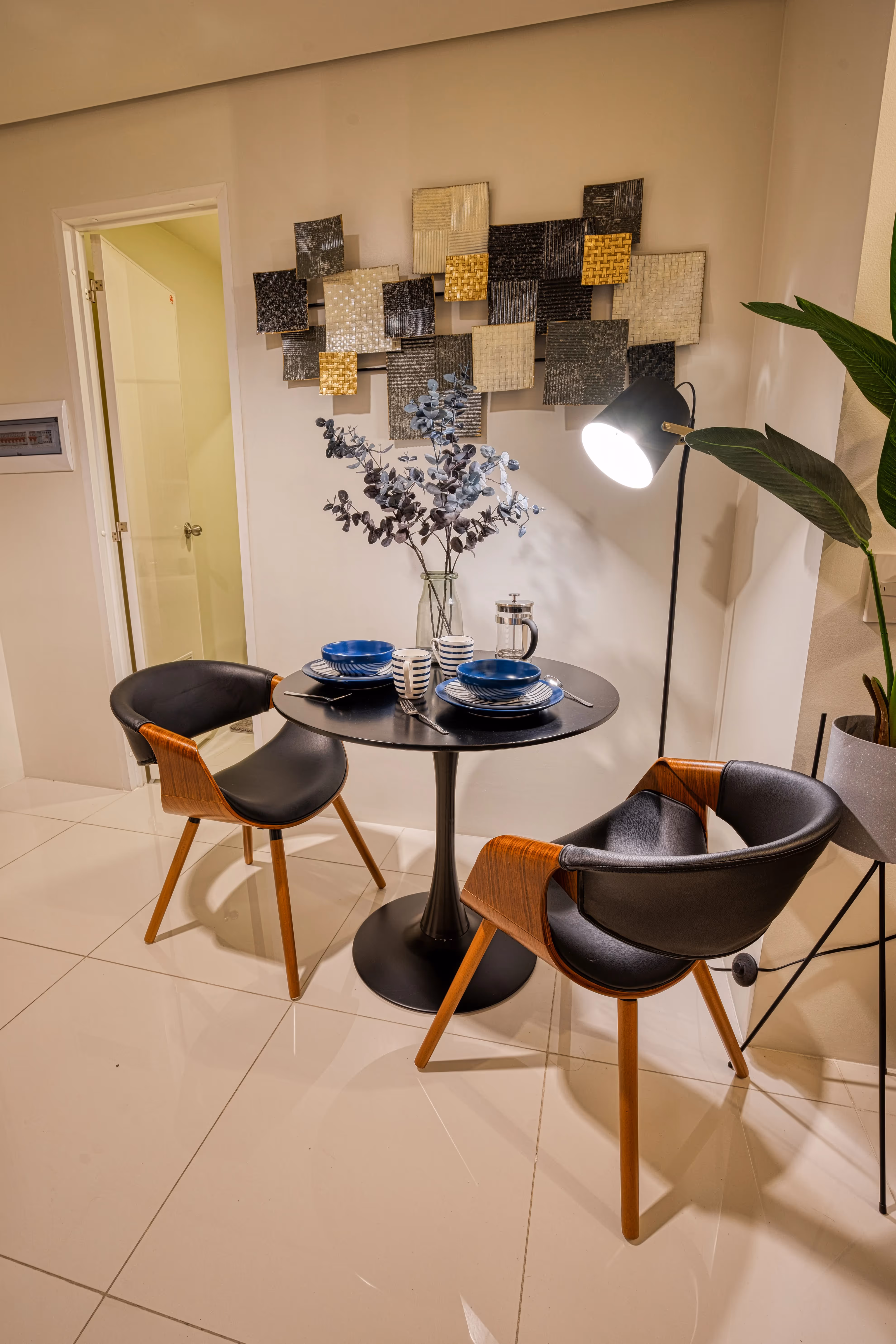 Compact dining area with modern four-seater table and decorative wall art at 3Torre Lorenzo.