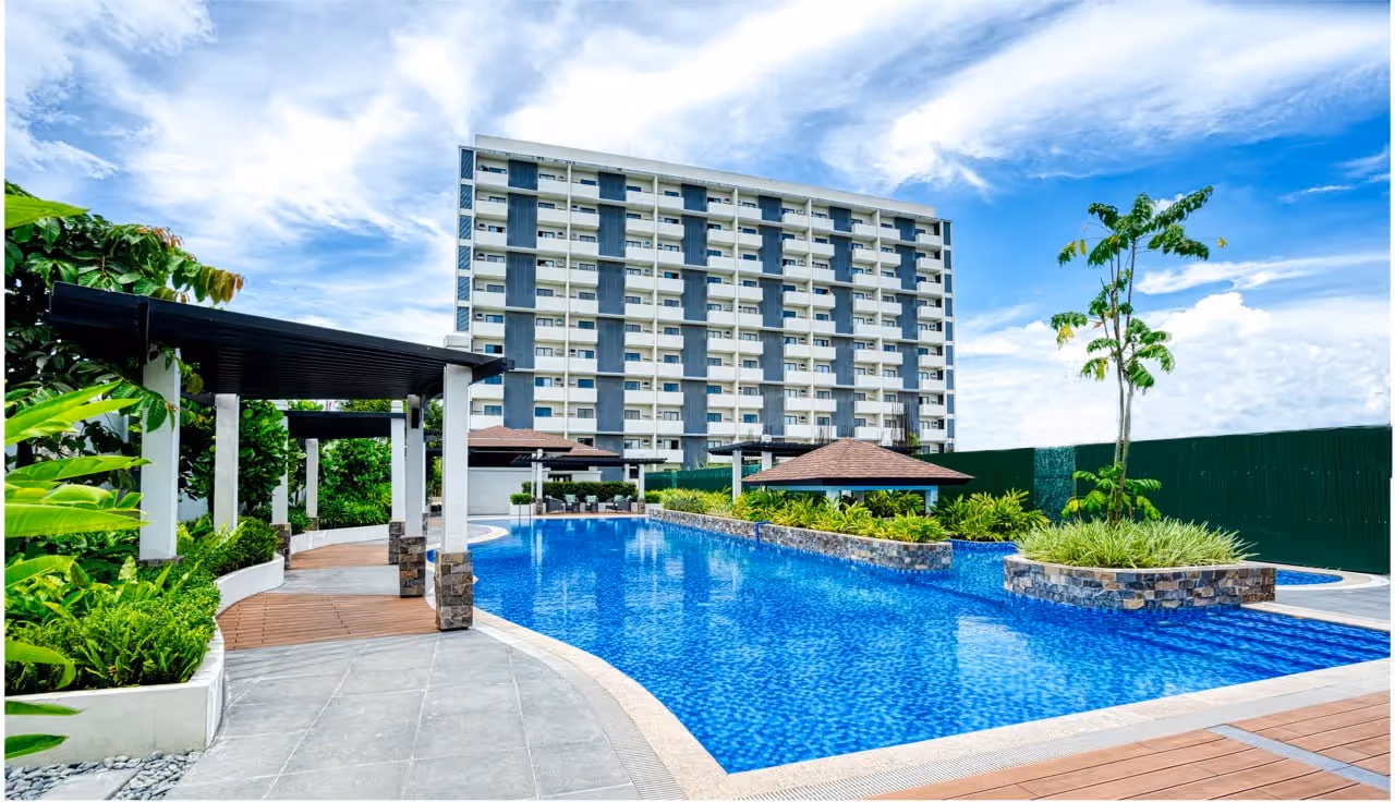a swimming pool condo amenity with a building in the background