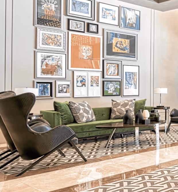 The Suites at Torre Lorenzo Malate lobby filled with furniture and pictures on the wall.