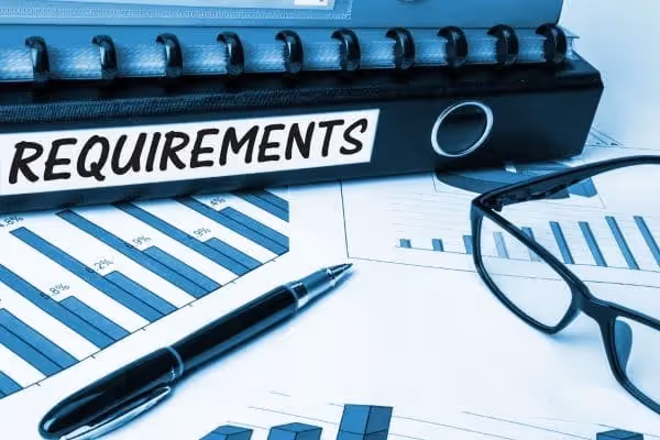 Binder labeled requirements with charts and glasses
