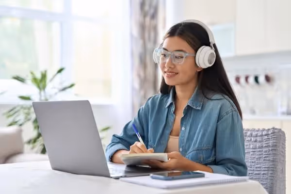 Woman studying online with headphones and laptop