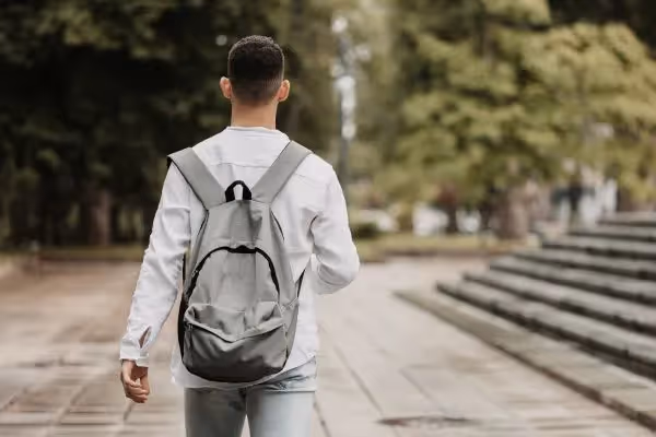 Man walking outdoors with a backpack