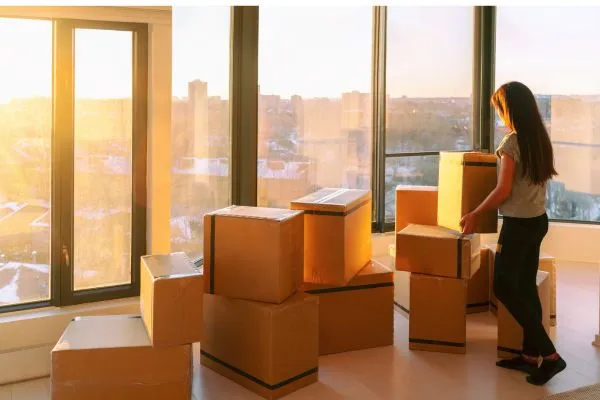 Woman organizing moving boxes in a high-rise apartment