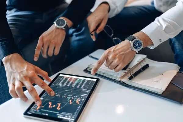 Businessmen analyzing stock market data on tablet