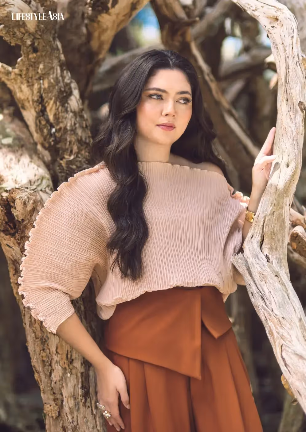 Woman posing among tree branches in outdoor portrait shoot