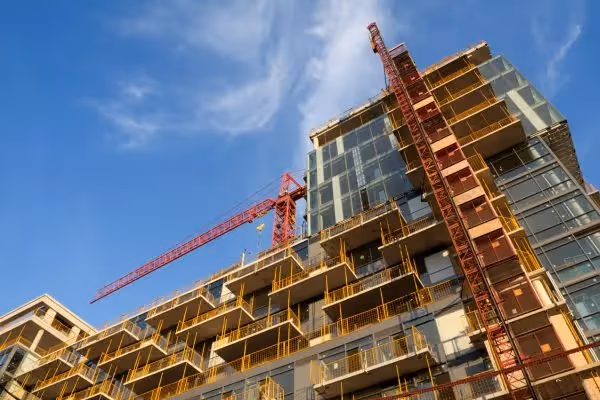 High-rise building under construction with tower cranes