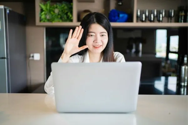 A remote worker woman at a table with her laptop