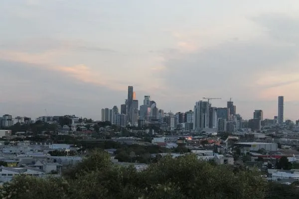 Urban skyline at sunset with buildings and residential area in foreground