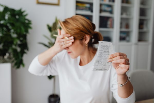 A woman presents a paper in front of her face, potentially addressing condo living costs.