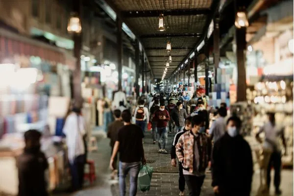 A bustling market in Davao, filled with people walking among stalls and vibrant displays of goods.