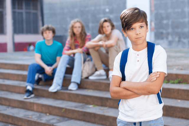 Chico solitario mirando hacia afuera, ilustrando ausentismo escolar.