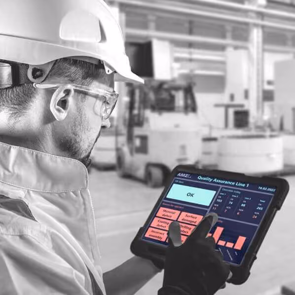 Ein Werker mit Schutzhelm und Tablet nutzt die Peakboard BYOD-Anwendung auf einem Industrietablet in einer Produktionsumgebung zur Qualitätskontrolle.
