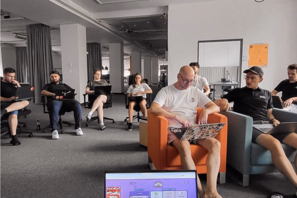 Peakboard-Teammitglieder bei einem entspannten Austausch im modernen Büro.