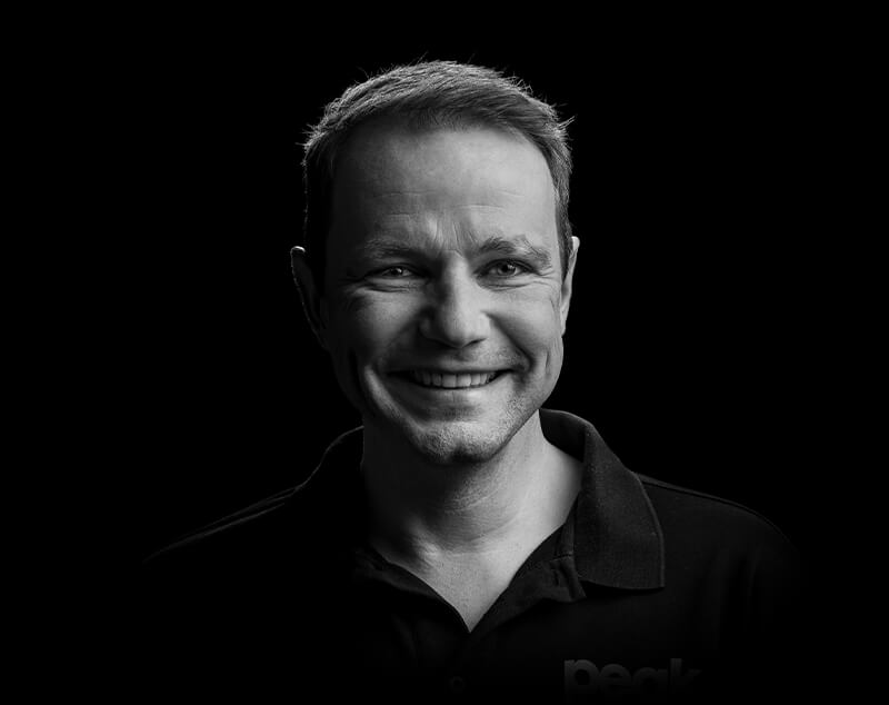 Portrait of team member Patrick smiling in a modern office setting