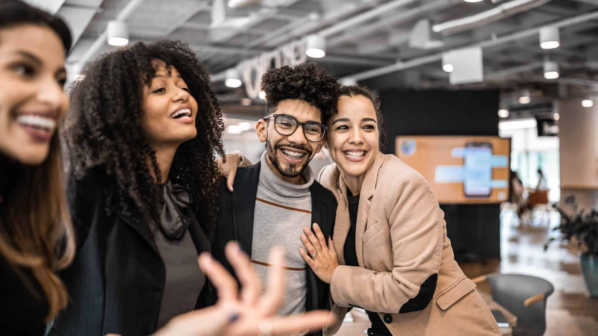 Motivated team collaborating on OKR planning in a bright modern office, discussing goals around a laptop