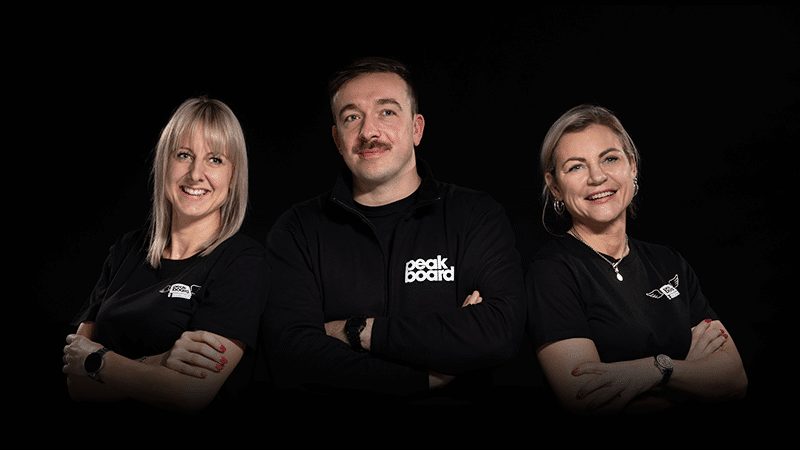 Event photo of a small team collaborating around a digital dashboard screen