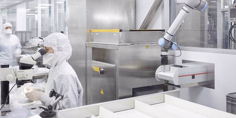 Mitarbeitende in einem Reinraum überwachen Fertigungsprozesse für Kunststoff- und Medizintechnikprodukte mit Unterstützung automatisierter Anlagen.