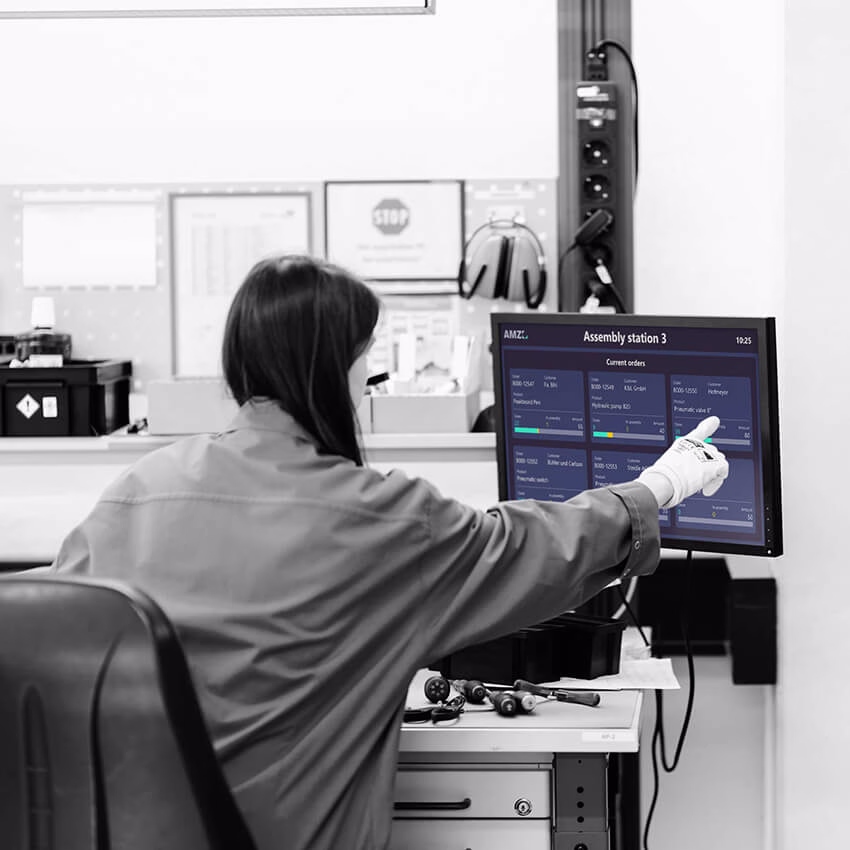 Assembly worker checks real-time production data on an interactive worker assistance system.