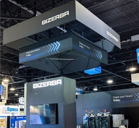 Messestand von Bizerba auf einer Fachmesse mit beleuchteten Displays und Industrieanlagen.