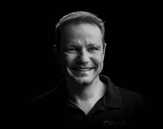 Portrait of Patrick, smiling employee in the office, half-length.