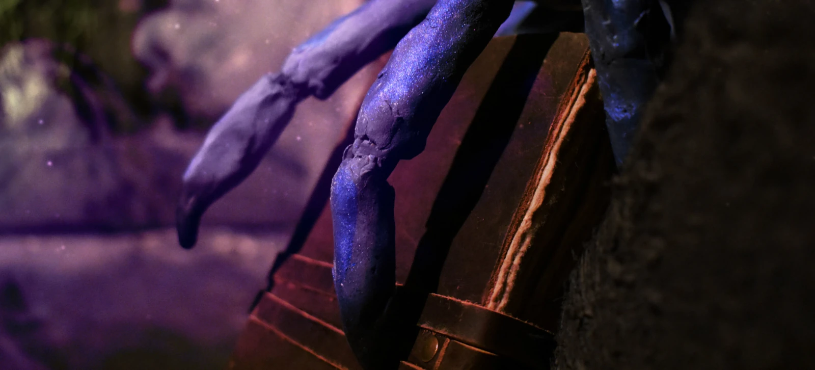 Des doigts reptiliens se ferment sur un grimoire