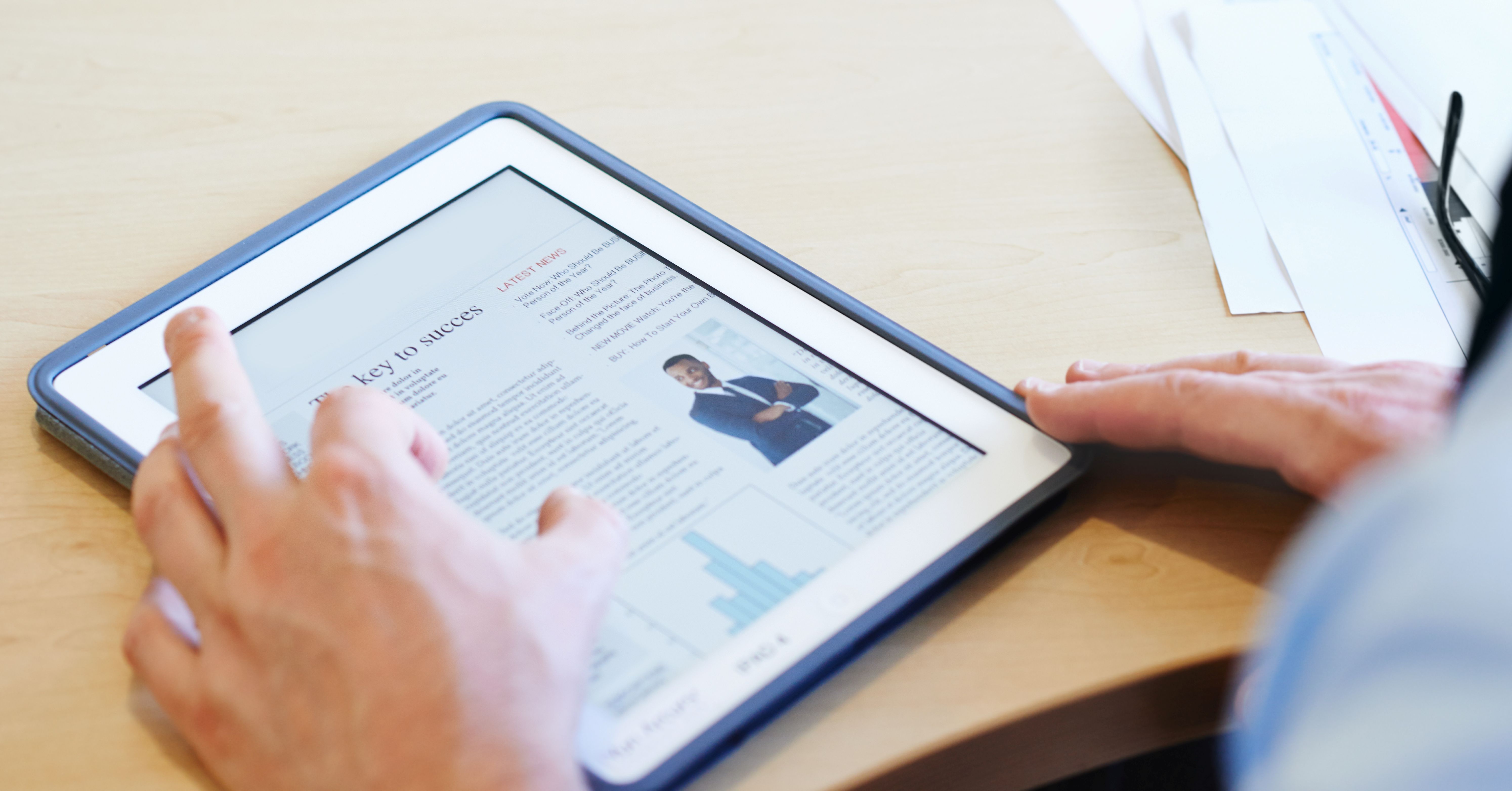 Tablet displaying a “Key to Success” article about SaaS M&A marketing integration